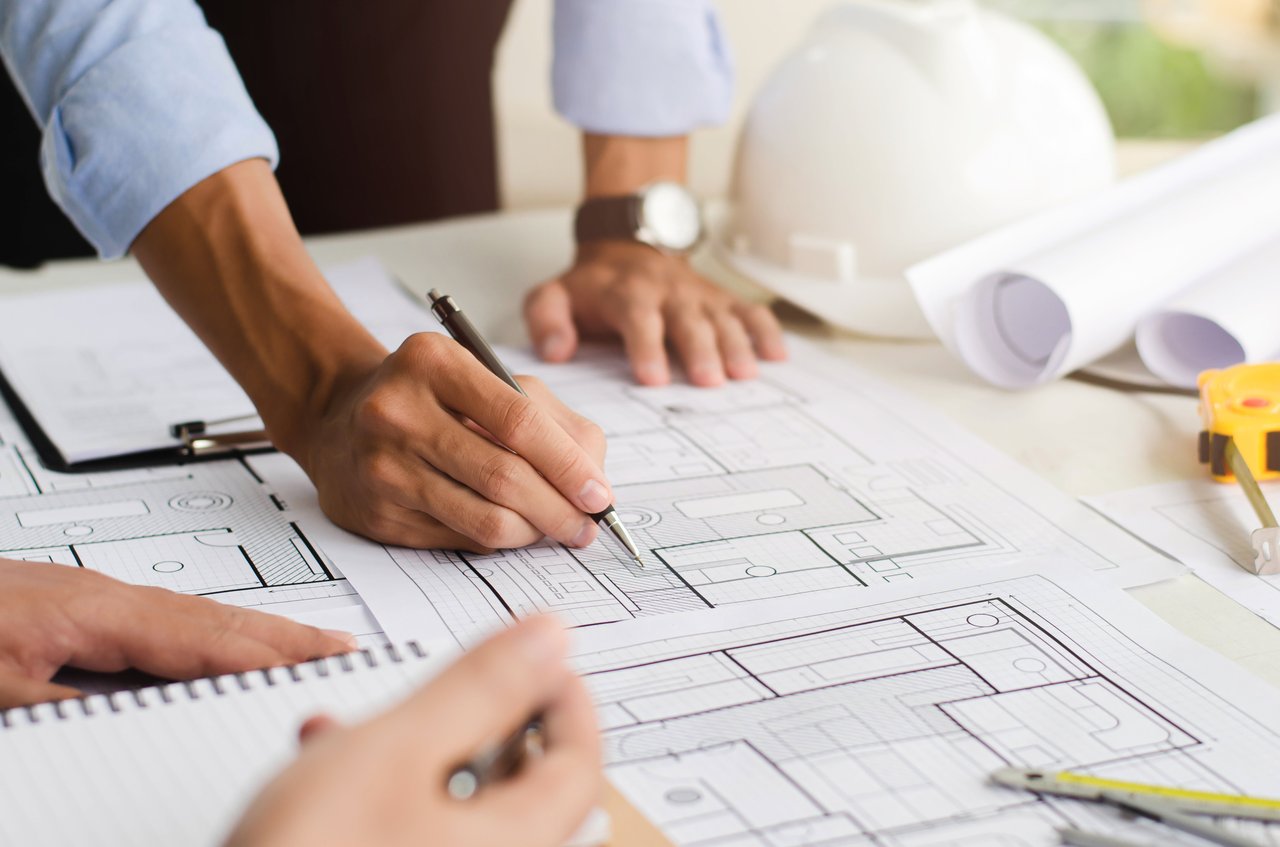 Architect reviewing structural drawings at a project table